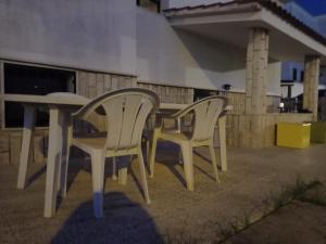 2 sedie bianche e un tavolo su un patio di Marina Piccola Apartment a Bari