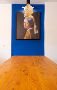 a picture of a painting of a woman on a wall at La chica de la perla in Torremolinos