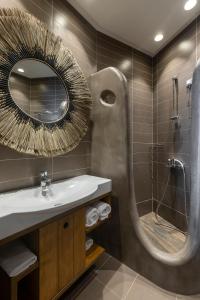 Anastasia Hotel & Suites Mediterranean Comfort في كاريستوس: حمام مع حوض ودش مع مرآة