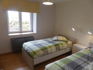 1 dormitorio con 2 camas y 2 ventanas en Gîte du Paquis, en Florenville