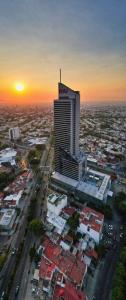 eine Luftansicht einer Stadt mit einem hohen Gebäude in der Unterkunft Riu Plaza Guadalajara in Guadalajara