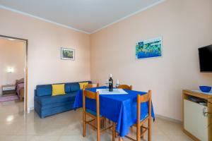 ein Wohnzimmer mit Tisch und Couch in der Unterkunft Apartments Maria in Poreč
