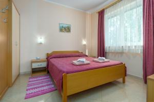 ein Schlafzimmer mit einem Bett mit zwei Handtüchern darauf in der Unterkunft Apartments Maria in Poreč