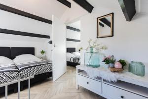 a bedroom with white walls and a black and white bed at Holiday Home Oostkapelle in Oostkapelle