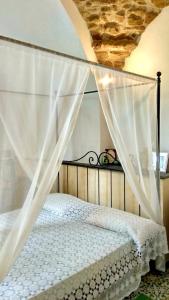 a bedroom with a canopy bed with white curtains at Il Limoneto degli Angeli in Minori