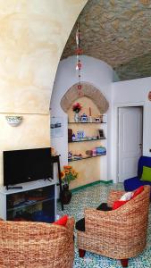 uma sala de estar com duas cadeiras e uma televisão em Il Limoneto degli Angeli em Minori