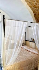 1 dormitorio con cama con dosel y cortinas blancas en Il Limoneto degli Angeli en Minori