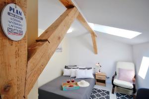 um quarto com uma cama e cadeiras num sótão em Plaża Apartament em Ustronie Morskie