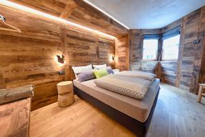 a bedroom with wooden walls and a bed in a room at Chrys b&b in Valfurva