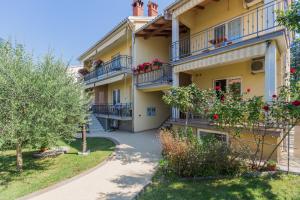 ein Apartmenthaus mit Balkonen und Bäumen im Hof in der Unterkunft Apartments Maria in Poreč