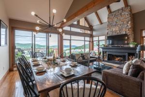 une salle à manger avec une table et une cheminée dans l'établissement Altitude Ski Inout 3 Bdrs W Sauna And Hot Tub, à Mont-Tremblant