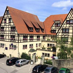 a large building with cars parked in a parking lot at Prinzhotel Rothenburg in Rothenburg ob der Tauber