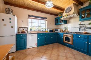 a kitchen with blue cabinets and a white refrigerator at Villa Oasis Galé - Luxury Villa with private pool, AC, free wifi, 5 min from the beach in Albufeira