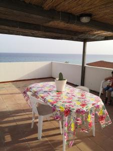 una mesa con un mantel florido y una planta en ella en A casa di Nanè, en Marina di Ragusa