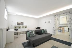 een slaapkamer met een bank en een bureau in een kamer bij Christina's Home in Desenzano del Garda
