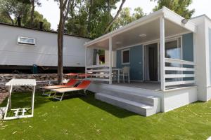 a tiny house with a porch and a swing at Porto Pirrone Camping in Leporano