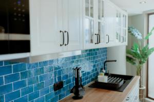 a kitchen with blue tile on the wall at Rooftop Marina ll by Madeira Best Apartments in Funchal +16 photos