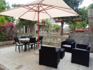 a patio with a table and chairs and an umbrella at Casa vacanze Sofia in Piano di Sorrento