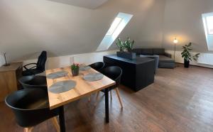 a living room with a wooden table and black chairs at SG Apartmánový dům Hoŕice in Hořice