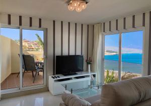 salon z telewizorem i widokiem na ocean w obiekcie Apartamentos Fuerteventura Sol w mieście Costa Calma