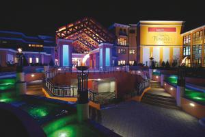 EurothermenResort Bad Schallerbach - Hotel Paradiso Superior في باد شاليرباخ: مجموعة من المباني في الليل مع أضواء خضراء