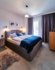 a bedroom with a large bed with a blue blanket at LAGUNA Apartament Polanica Residence 36 LUX in Polanica-Zdrój