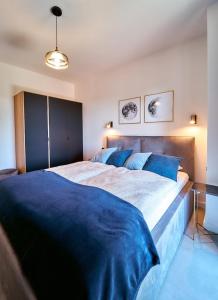 1 dormitorio con 1 cama grande con sábanas azules en LAGUNA Apartament Polanica Residence 36 LUX, en Polanica-Zdrój