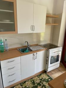 a kitchen with white cabinets and a sink and a stove at Villa del Sole in Terracina