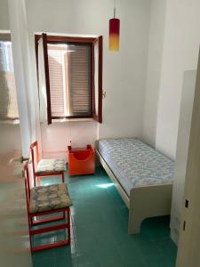 a small room with a bed and a chair at Villa del Sole in Terracina
