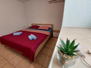 sypialnia z łóżkiem z 2 poduszkami i rośliną w obiekcie Sofija apartmani w mieście Vir
