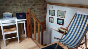une pièce avec une chaise, une table et un escalier dans l'établissement La Goélette Beau duplex A 150 m du centre ville et 400m de la plage de l'écluse, à Dinard 19 autres photos