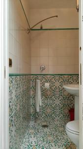 a bathroom with a toilet and a tiled floor at Il Limoneto degli Angeli in Minori +23 photos