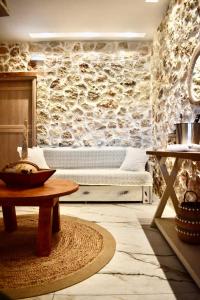 una sala de estar con una pared de piedra y un banco. en Ktima Panagias en Ormos Panagias