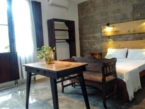 a bedroom with a bed and a table and a desk at Aloja Merlo in Merlo
