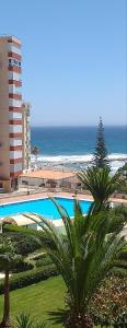 a swimming pool next to a beach and a building at Studio La Concha direkt am Meer in Torrox Costa