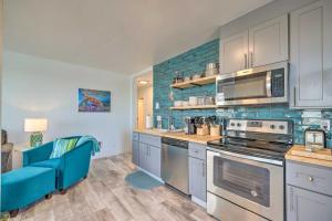 cocina con electrodomésticos de acero inoxidable y sofá azul en Adorable Downtown Studio - 1 Block to Long Beach! en Long Beach