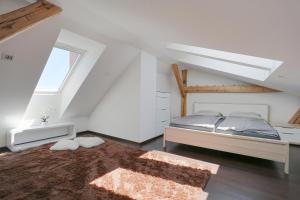 Habitación blanca con cama y ventana en Loft Apartmán Šumava, en Sušice