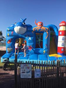 a blue inflatable bounce house with two children in it at ALINOA in Ouistreham