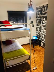 1 dormitorio con 2 literas y escritorio con ordenador portátil en Casa de Katiolo, en Figueira de Castelo Rodrigo