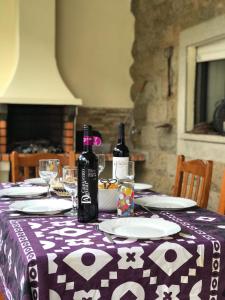 una mesa con dos botellas de vino y platos en ella en Casa de Katiolo, en Figueira de Castelo Rodrigo