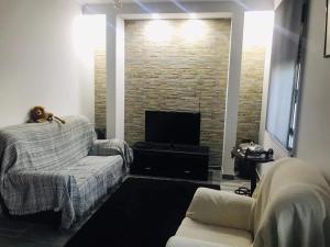 a living room with a couch and a television at Casa de Katiolo in Figueira de Castelo Rodrigo
