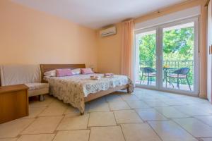 a bedroom with a bed and a balcony at Amfora Apartments in Crikvenica