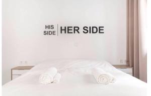 a white bed with a sign that reads his side her side at Dion Suites in Athens