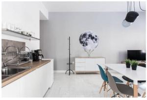 a white kitchen with a table and chairs and a table at Dion Suites in Athens