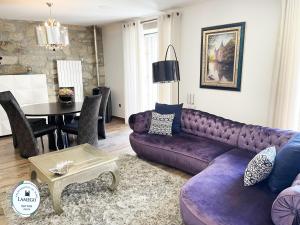 uma sala de estar com um sofá roxo e uma mesa em Apartamento da Seara "Lamego" em Lamego