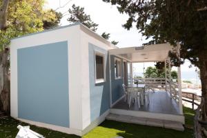 a small house with a blue and white exterior at Porto Pirrone Camping in Leporano