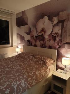 a bedroom with a bed with flowers on the wall at Apartman 33 FREE PRIVATE GARAGE in Novi Sad