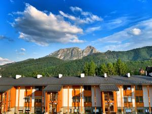 an apartment building with mountains in the background at Apartament Leśny z kominkiem - Viva Pod Giewontem Apartamenty in Zakopane