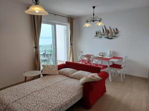 a bedroom with a red bed and a table with chairs at APARTMANI Mirona - Tučepi in Tučepi