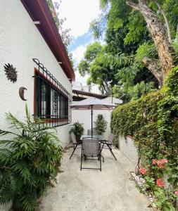 墨西哥城的住宿－Cozy Private Room，一个带桌子和遮阳伞的庭院